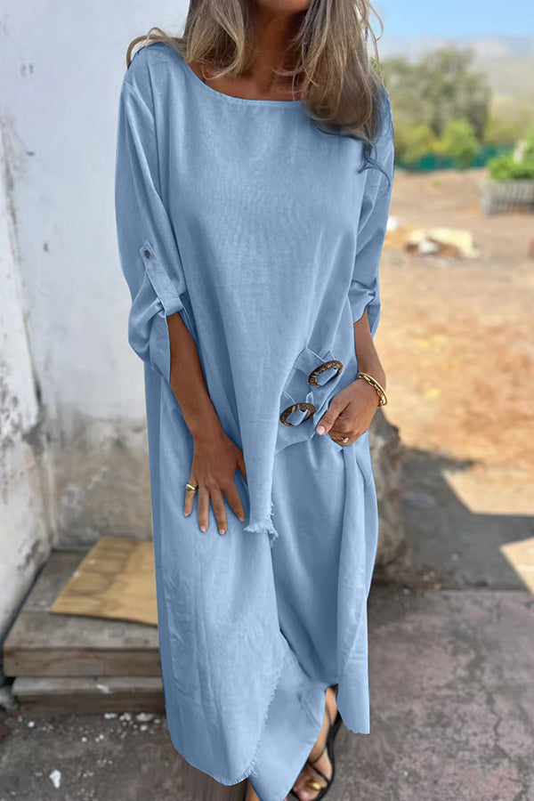 A woman wearing a flowing draped two-piece set with an asymmetric hem, relaxed and elegant.