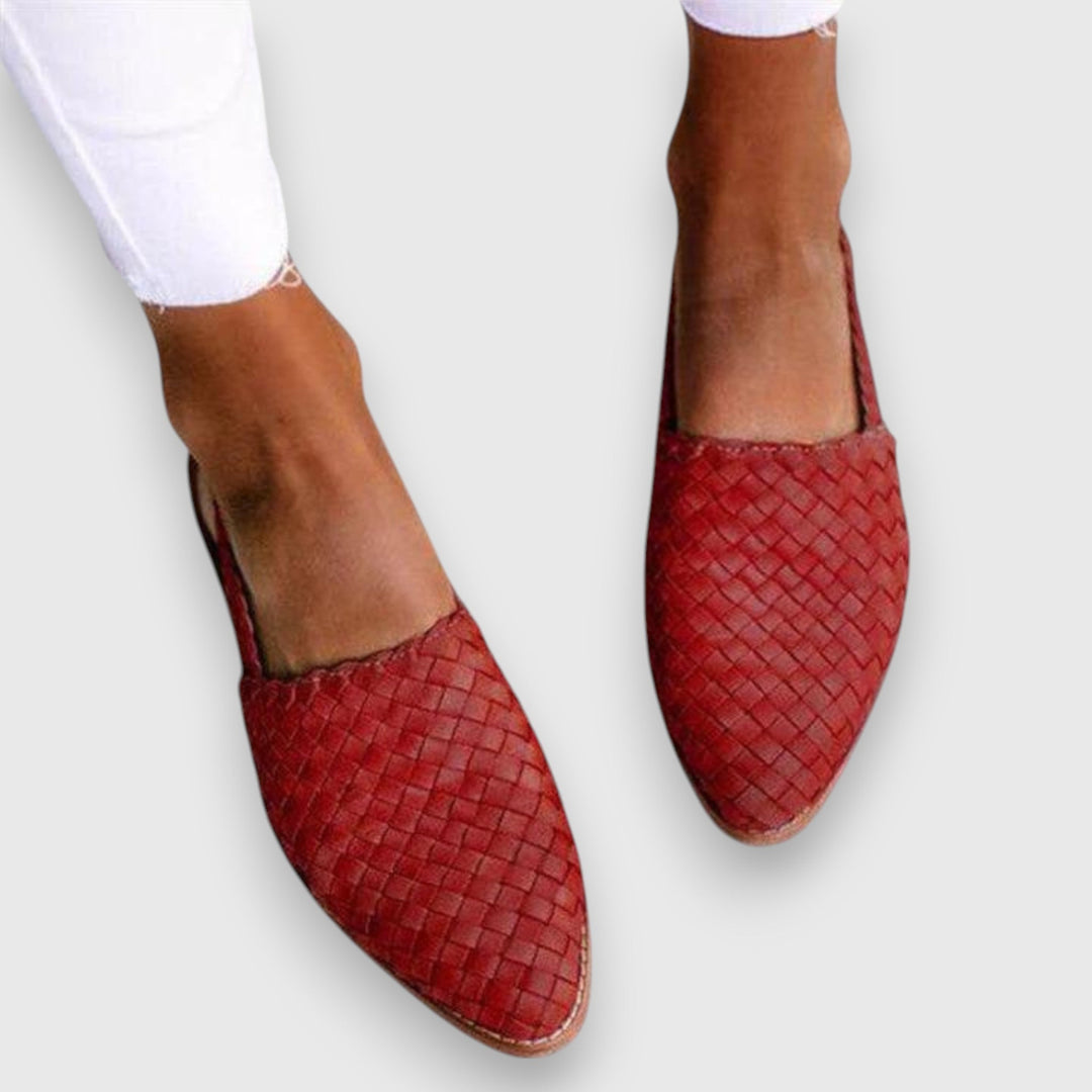 A woman wearing woven ballet flats with cropped jeans, looking relaxed and refined on a summer day.