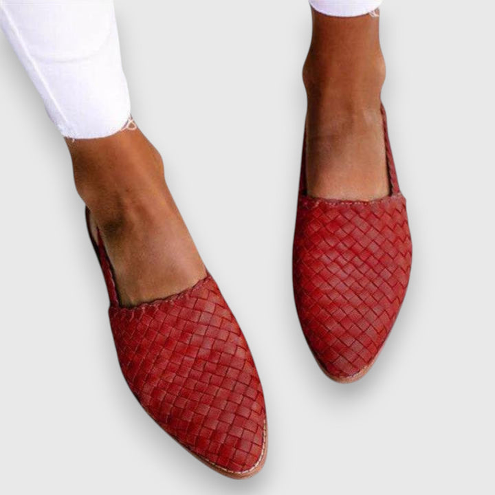 A woman wearing woven ballet flats with cropped jeans, looking relaxed and refined on a summer day.