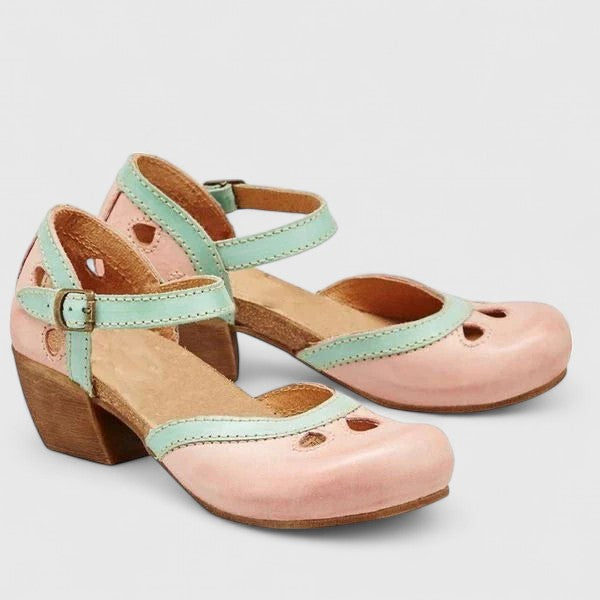 A woman in pastel pink and mint block heel sandals at a summer garden party.
