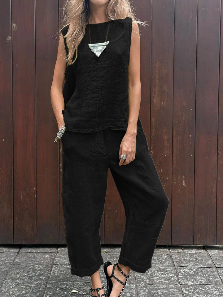 A woman wearing a relaxed sleeveless top with ankle-length trousers, easy and elegant.