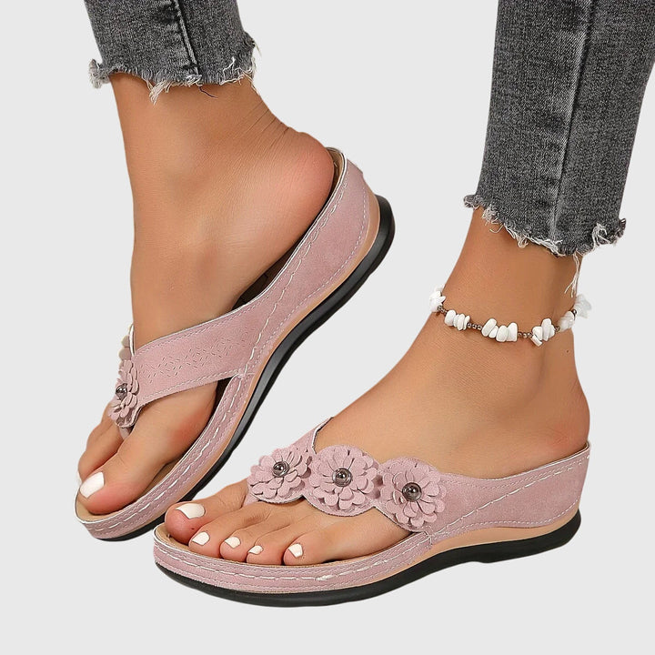 A woman wearing navy cushioned flip-flops with a supportive insole and open-front design.
