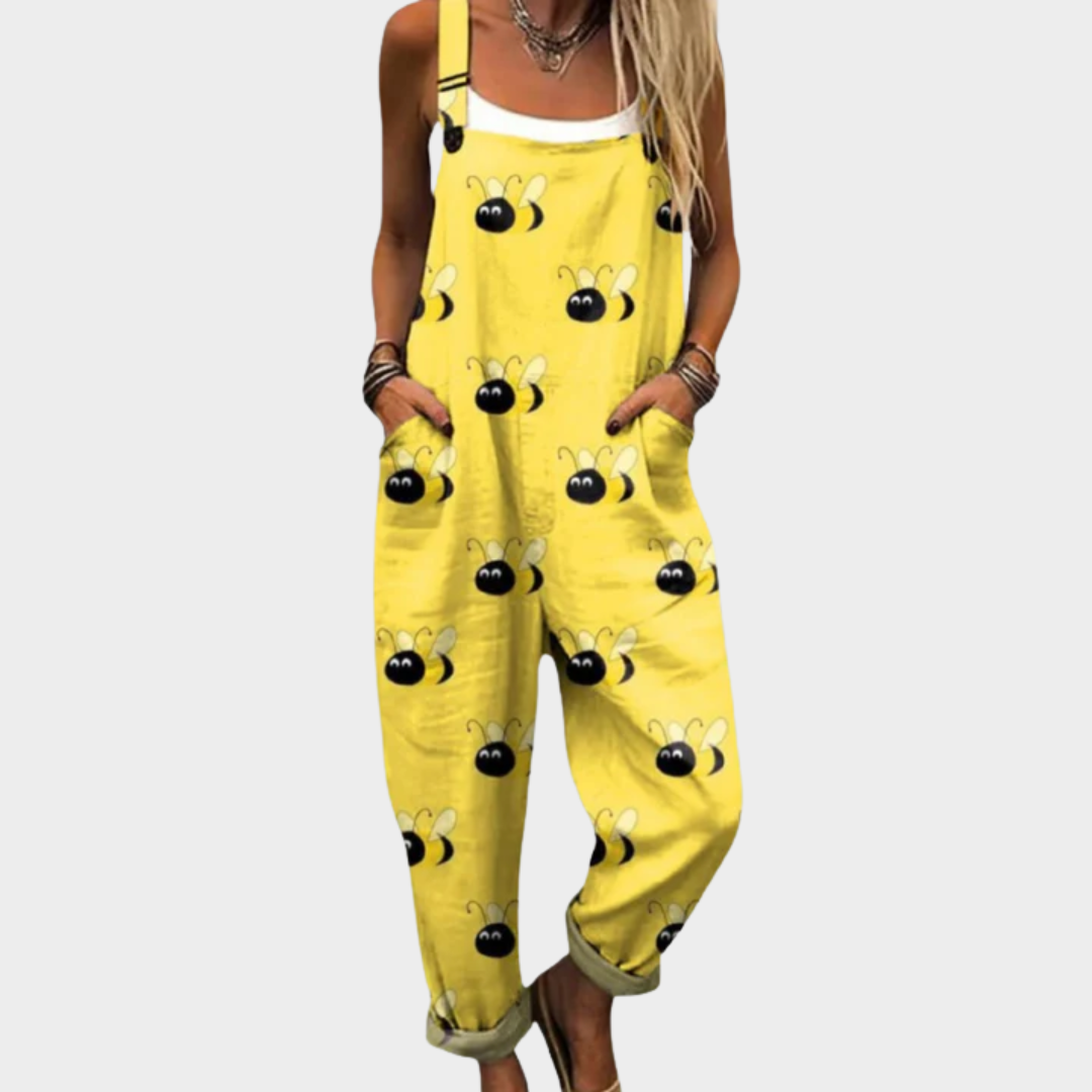 A woman smiling in bright yellow bee-print dungarees with a relaxed fit and adjustable straps.