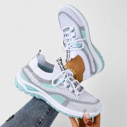 A woman lacing up light, breathable orthopaedic trainers before a walk.