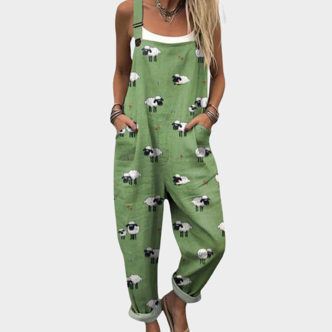 A woman wearing fresh green dungarees printed with charming little sheep, with adjustable straps.