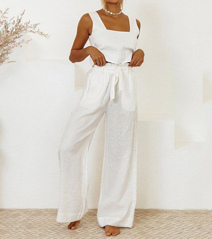 A woman wearing a minimal two-piece set with a square neckline and belted flared trousers.