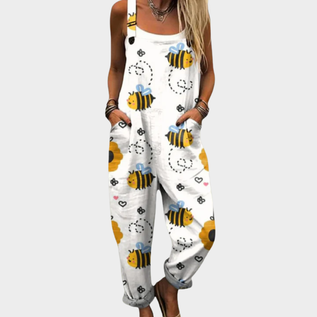 Woman wearing white dungarees printed with busy yellow-and-black bees and fine flourishes