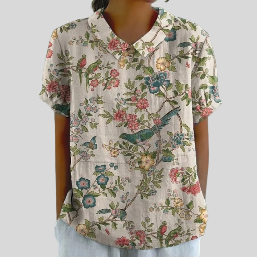 A woman wearing an elegant floral top with a refined collar at a relaxed lunch with friends.