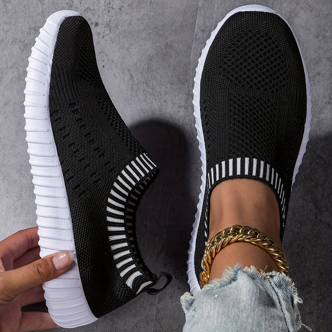 A woman slipping on ultralight sock-style trainers that hug the foot.