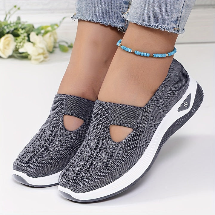 A woman stepping into easy slip-on comfort trainers with no laces.