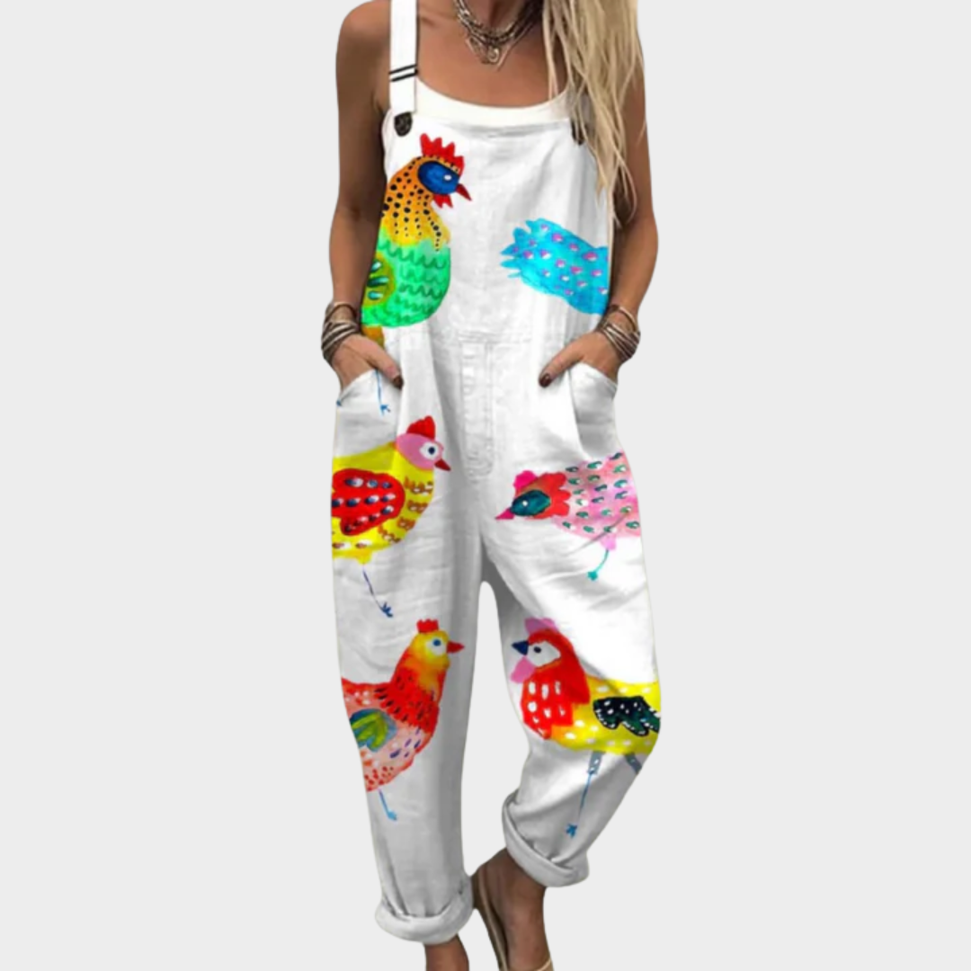 Woman wearing white dungarees printed with a cheerful flock of colourful hens