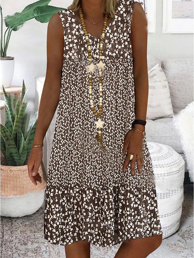 A woman wearing the Geraldine sleeveless V-neck floral dress on a sunny day outdoors.