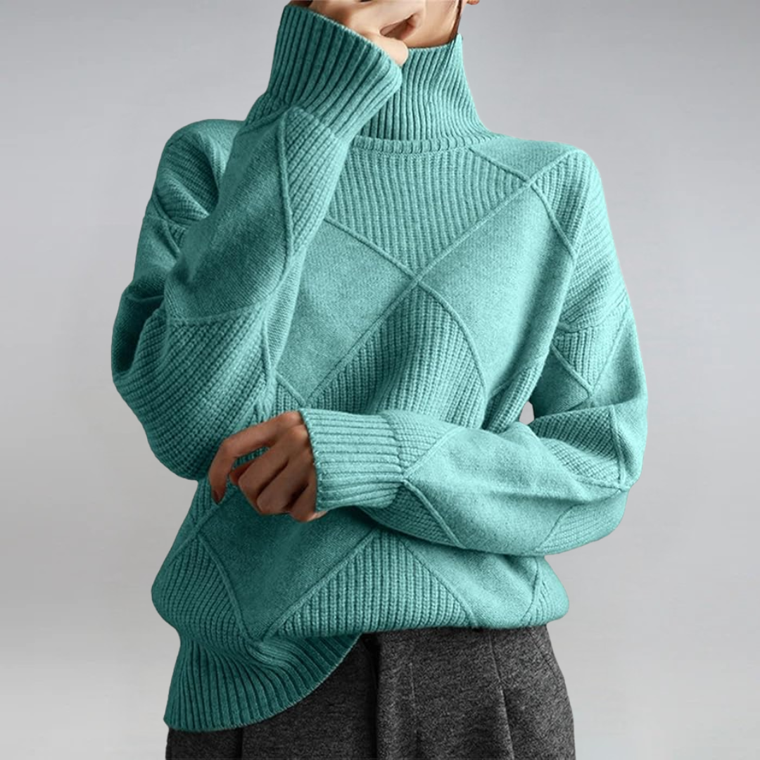 A woman in a stand-collar jumper with an elegant drape, styled with tailored trousers.