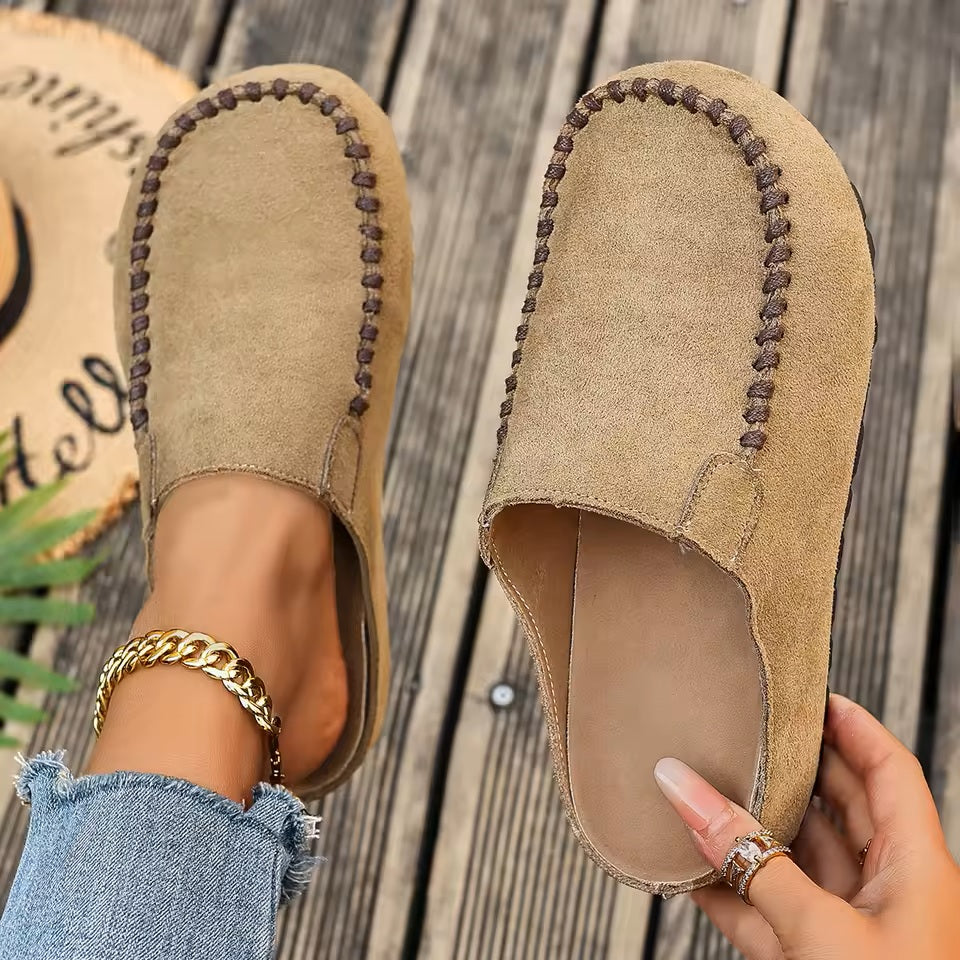 A pair of minimal slip-on loafers in warm brown with a soft footbed and open back