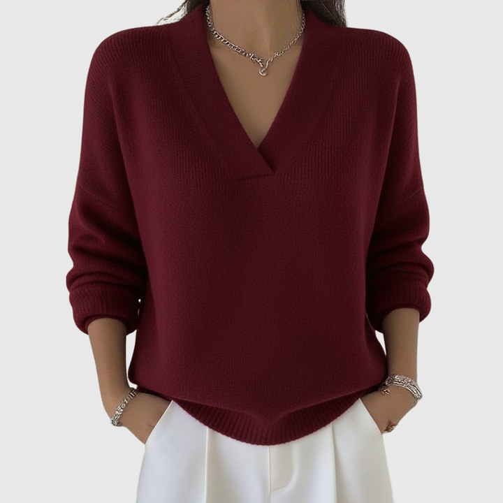 A woman wearing a soft draped V-neck jumper with jeans for an effortlessly elegant look.