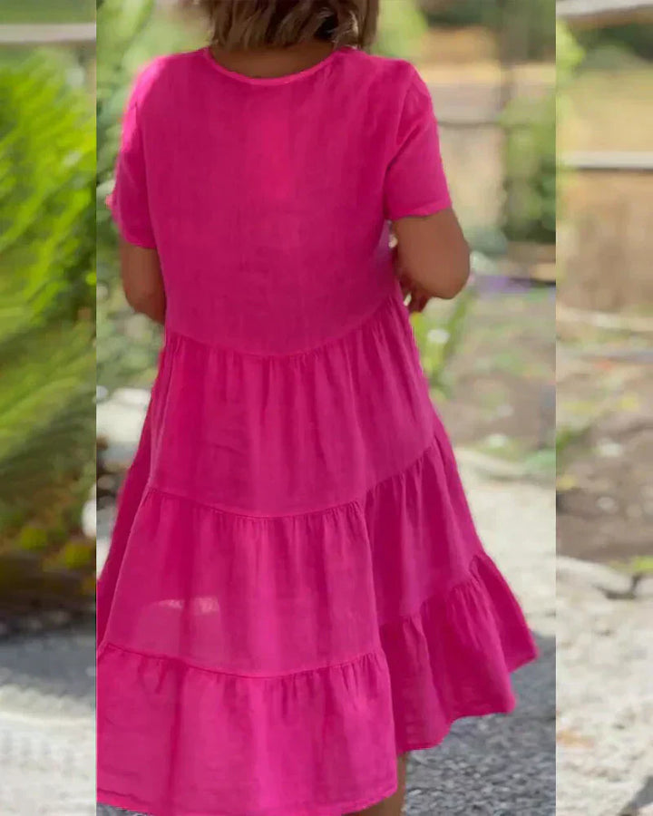 Woman wearing the Veronica™ V-neck summer dress with a soft layered skirt, strolling on a sunny afternoon.