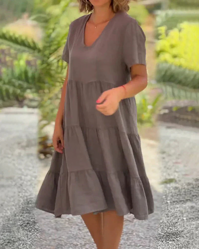 Woman wearing the Veronica™ V-neck summer dress with a soft layered skirt, strolling on a sunny afternoon.