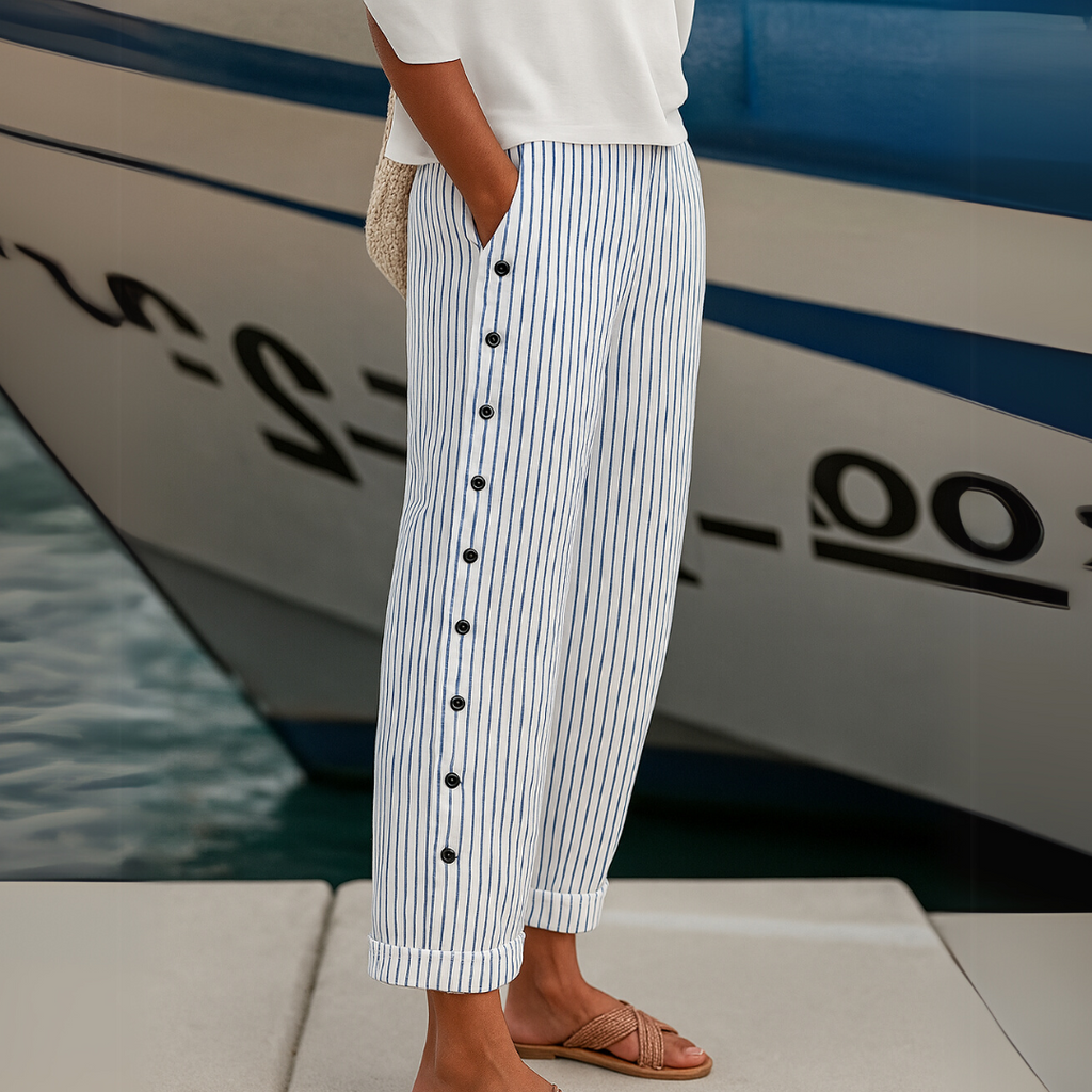 High-waisted striped trousers in black with decorative button detail along the waist