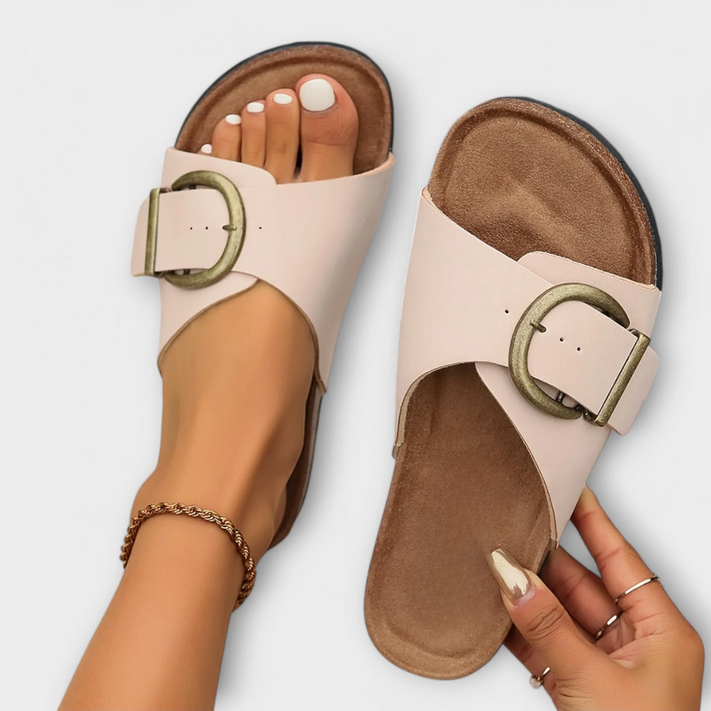 Black flat sandals with wide strap and decorative buckle detail