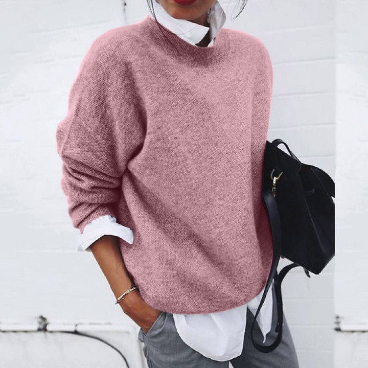 A woman wearing a soft mustard round-neck jumper with an elegant modern shape, relaxed and warm.