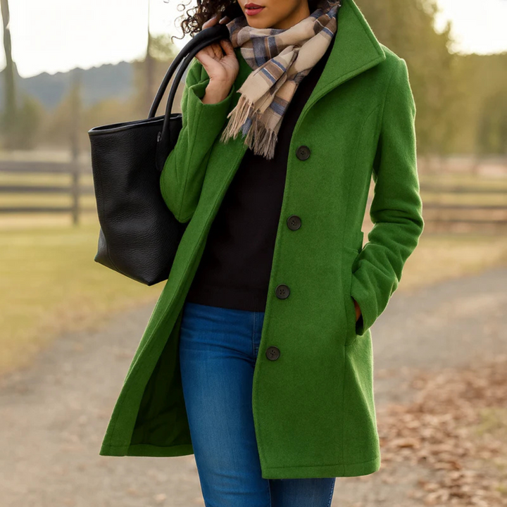 A woman wearing an elegant camel button-through coat over a jumper on a crisp autumn day.