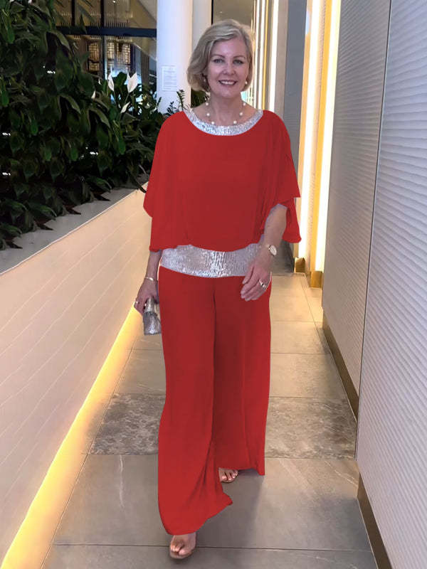 A woman wearing an embellished blouse-style top with softly flowing wide evening trousers.