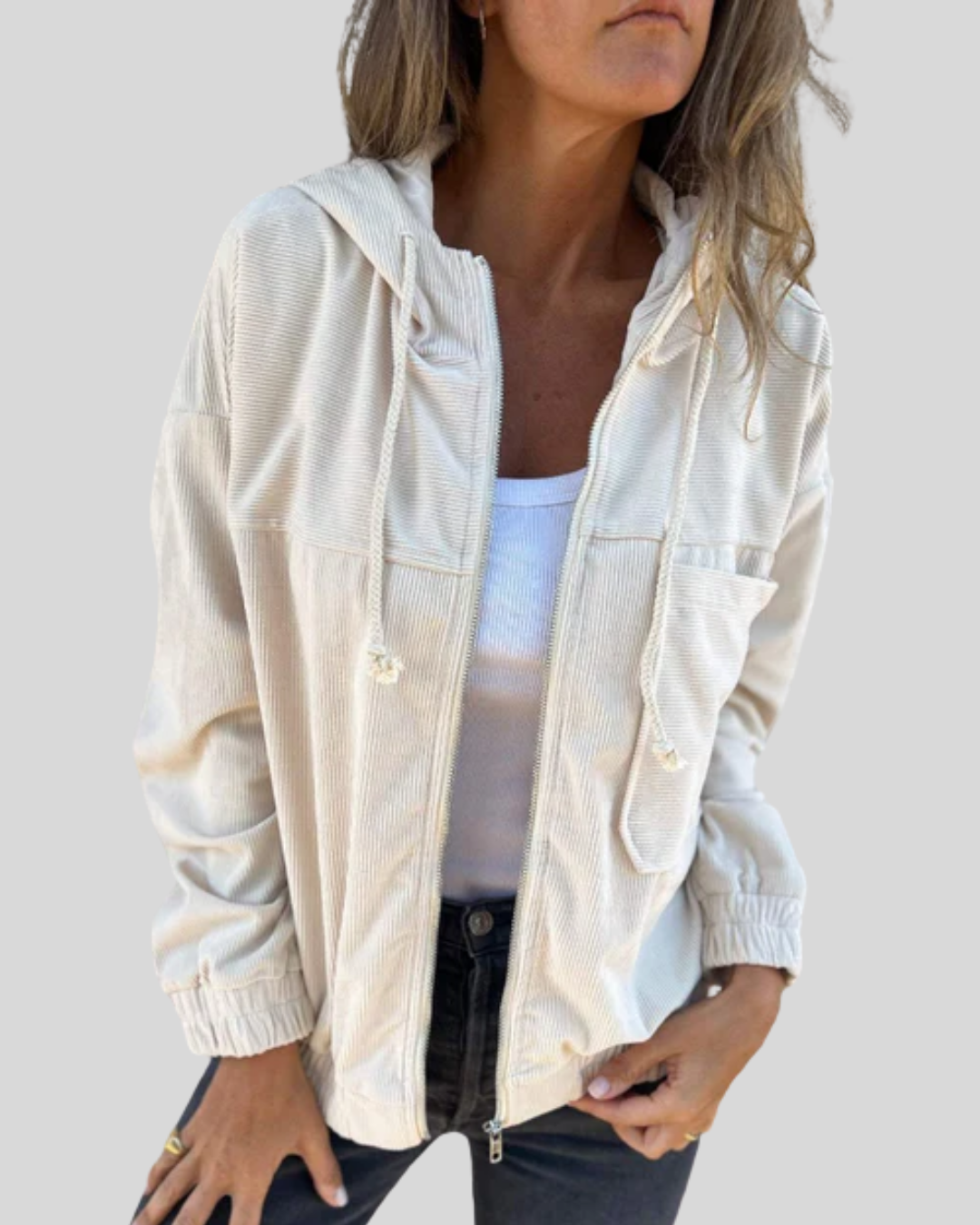 A woman wearing a blue zip-up hooded jacket with a soft ribbed texture and long sleeves.