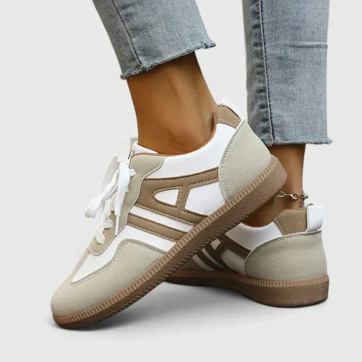 A woman wearing khaki and white orthopaedic trainers on a relaxed walk.