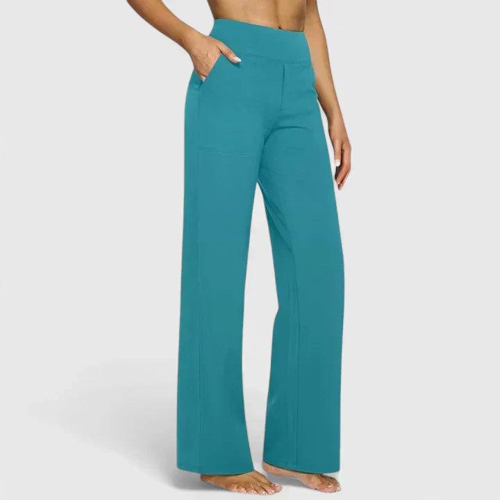 A woman in tailored trousers styled with a simple top for an elegant, comfortable everyday look.