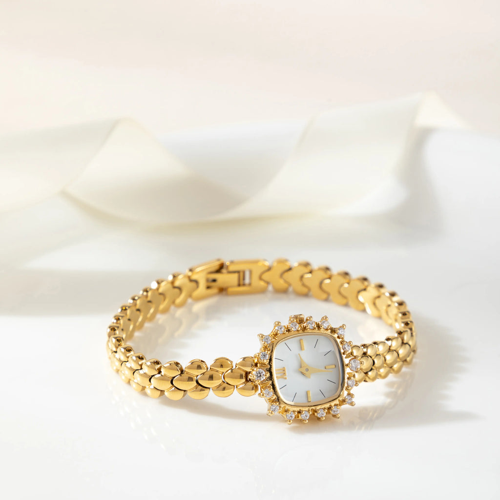 Slim women's bracelet watch with a vibrant colour detail against a simple light dial