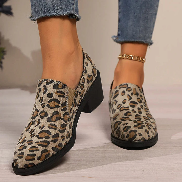 A woman wearing leopard-print loafers with jeans, stepping out with easy confidence.