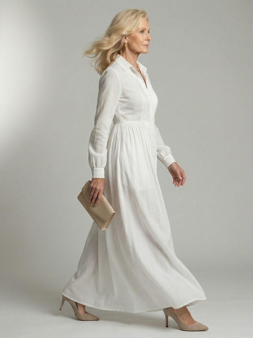 White long-sleeve button-front maxi dress with a gathered waist and full flowing skirt