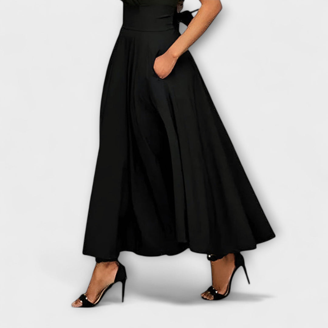 A woman in a flowing elegant maxi skirt styled with a simple top for a confident, striking look.