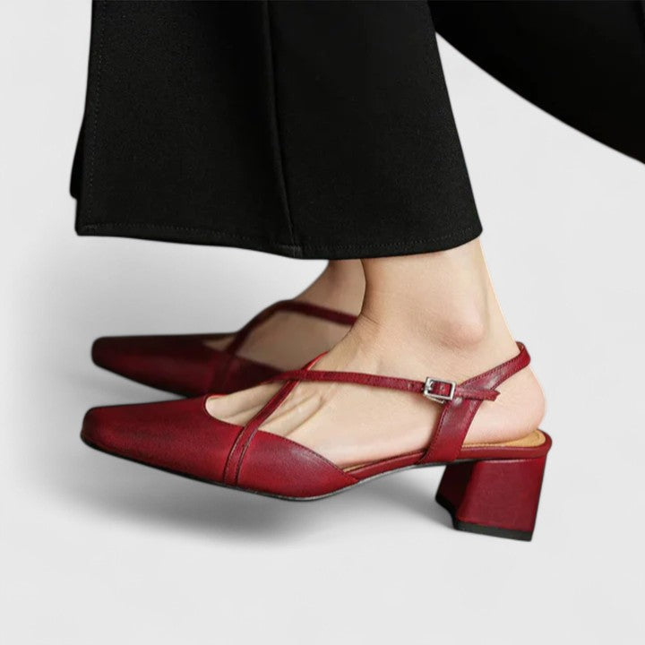 A woman wearing beige chic block heel sandals with an adjustable strap at an evening event.