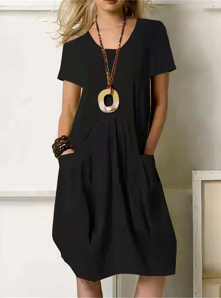Woman wearing the Pauline™ A-line midi dress with pockets and a round neckline, out on an everyday errand.