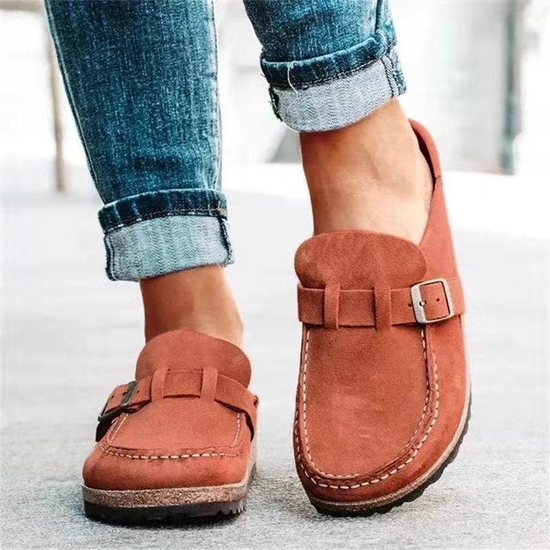A woman wearing soft green bow loafers with cropped jeans on a city stroll.