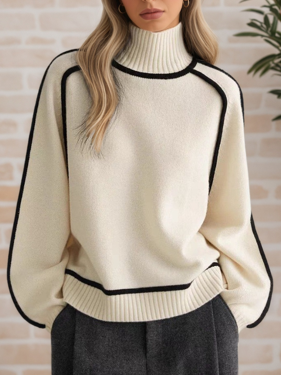 A woman wearing a funnel neck jumper with contrast piping, styled with trousers for a smart-casual look.