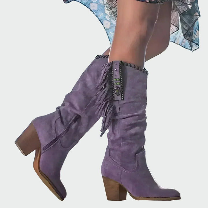 Woman wearing fringed boho-Western ankle boots with a floaty dress at a festival.