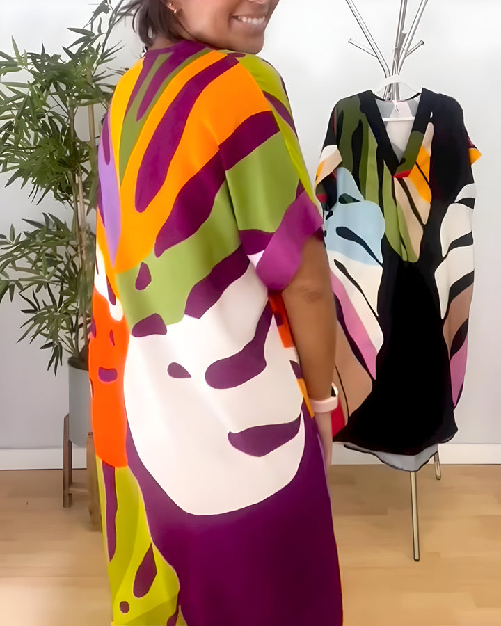 A woman wearing a colourful abstract print dress with a V-neckline and short sleeves.