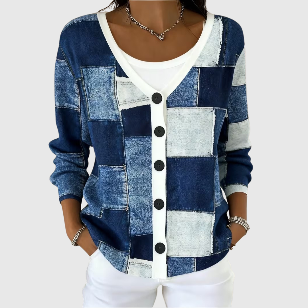 A woman wearing a classic button cardigan buttoned over straight trousers on a fresh morning.