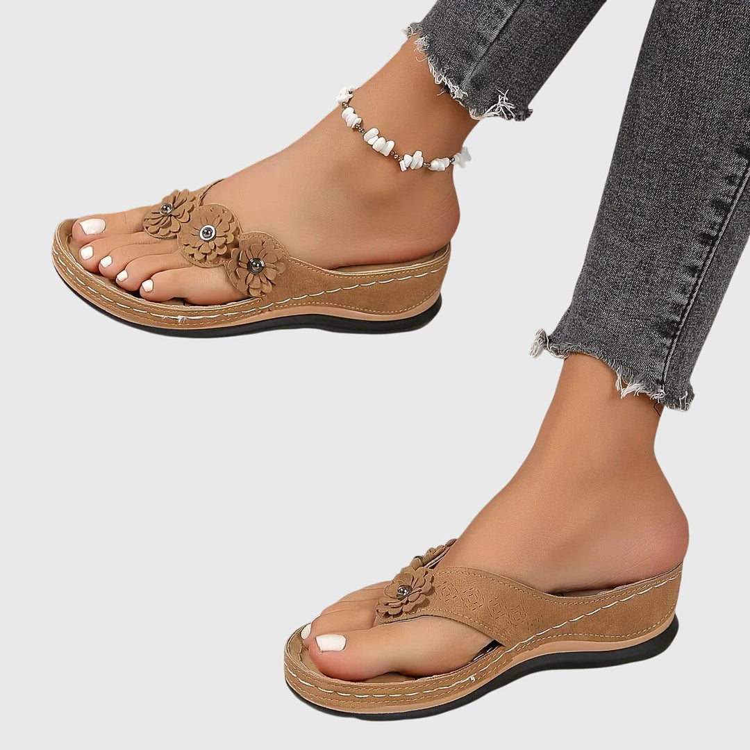 A woman wearing navy cushioned flip-flops with a supportive insole and open-front design.