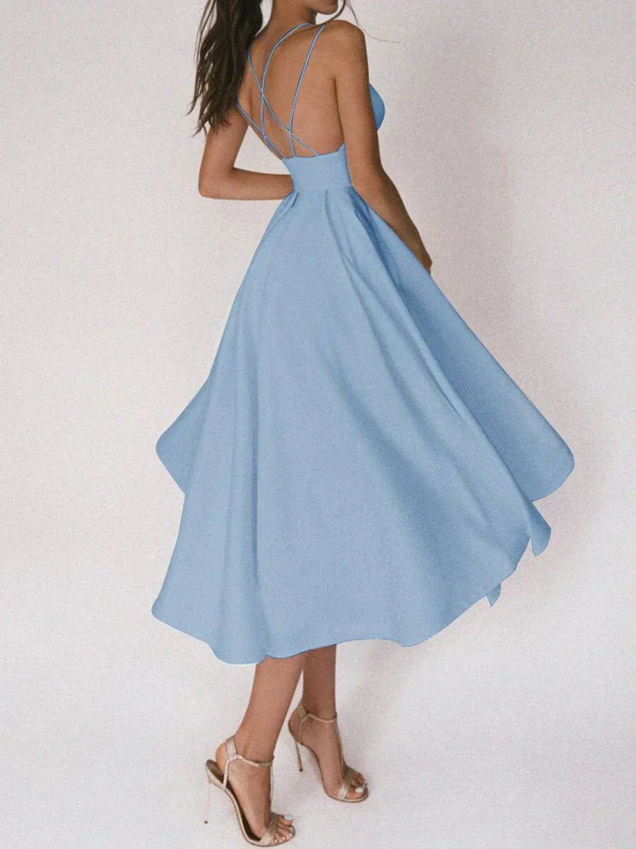 Woman at a summer celebration wearing the Katie minimalist maxi dress with fine double straps and a floating skirt.