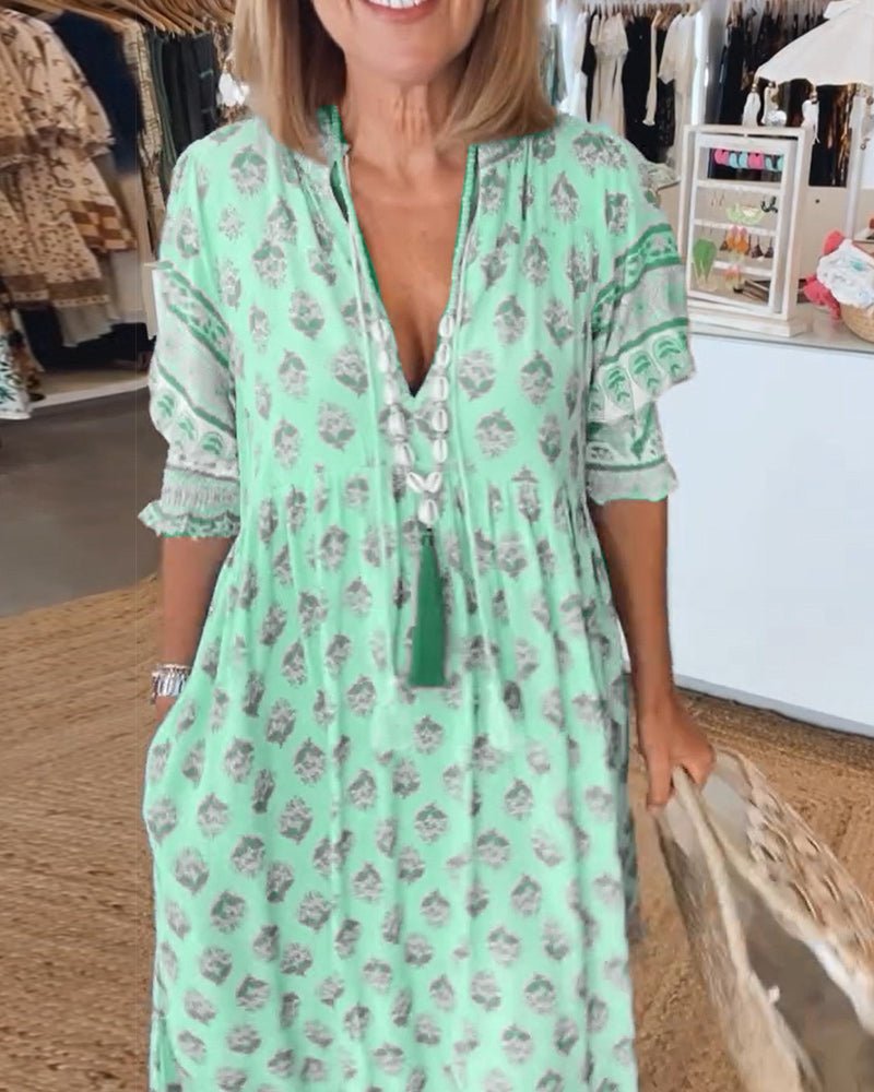 A woman wearing the Patricia boho floral midi dress with a fringed neckline and ruffled skirt.
