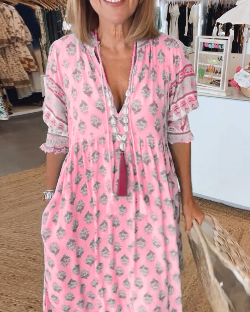 A woman wearing the Patricia boho floral midi dress with a fringed neckline and ruffled skirt.