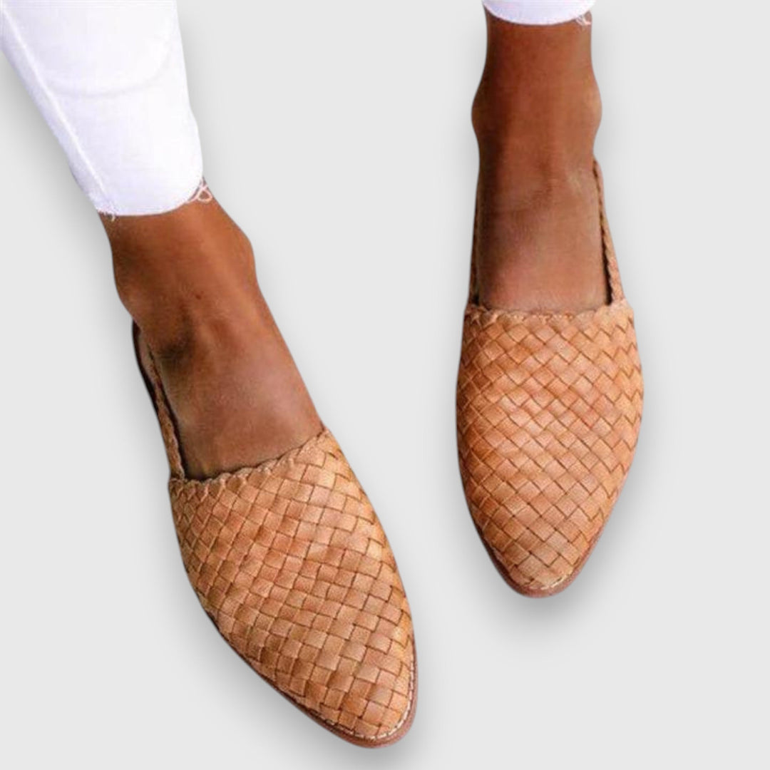 A woman wearing woven ballet flats with cropped jeans, looking relaxed and refined on a summer day.