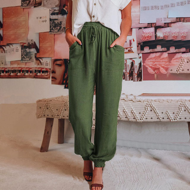 A woman in slim tapered drawstring joggers styled with sandals for an elegant, relaxed look.