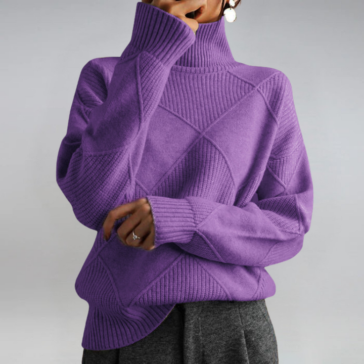 A woman in a stand-collar jumper with an elegant drape, styled with tailored trousers.