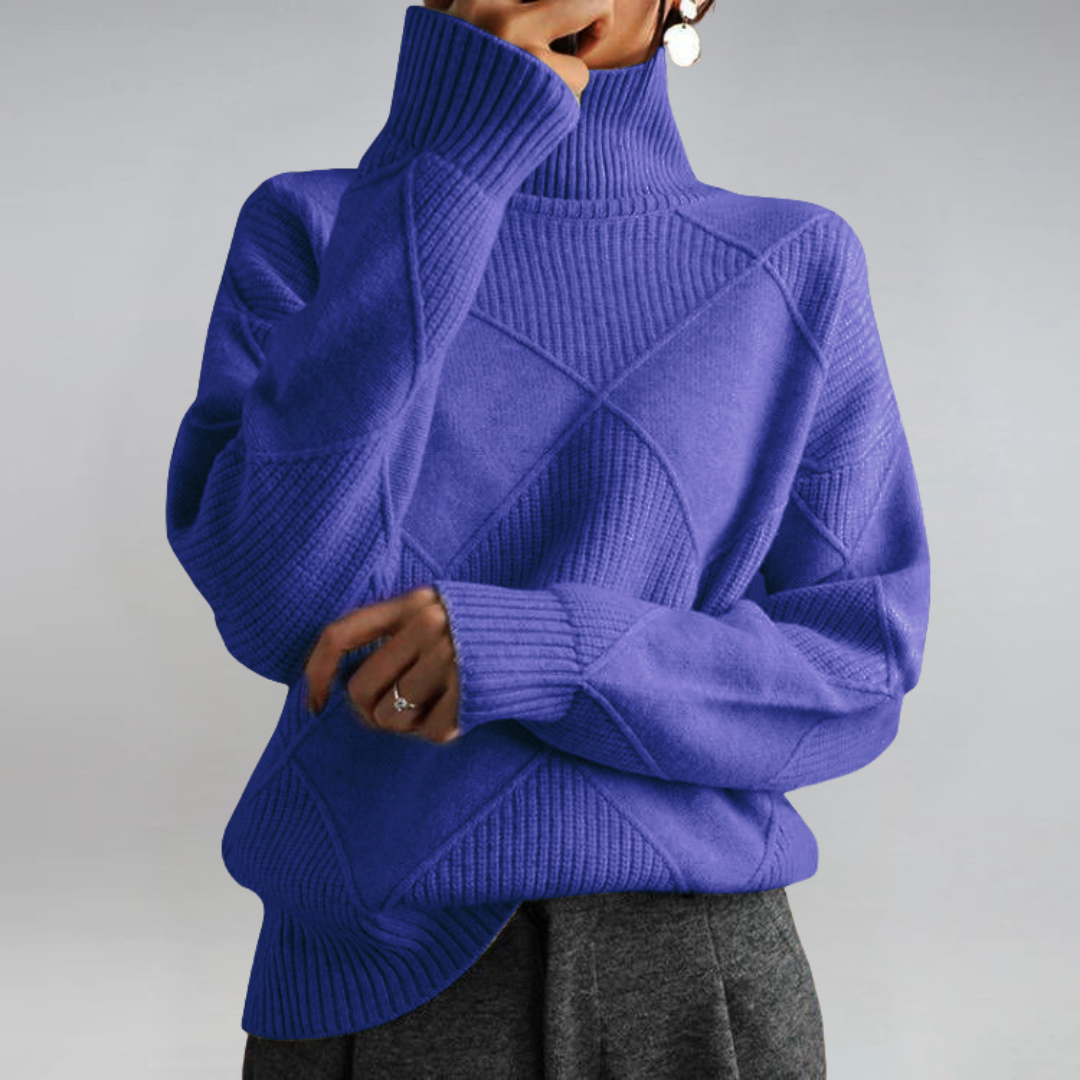 A woman in a stand-collar jumper with an elegant drape, styled with tailored trousers.