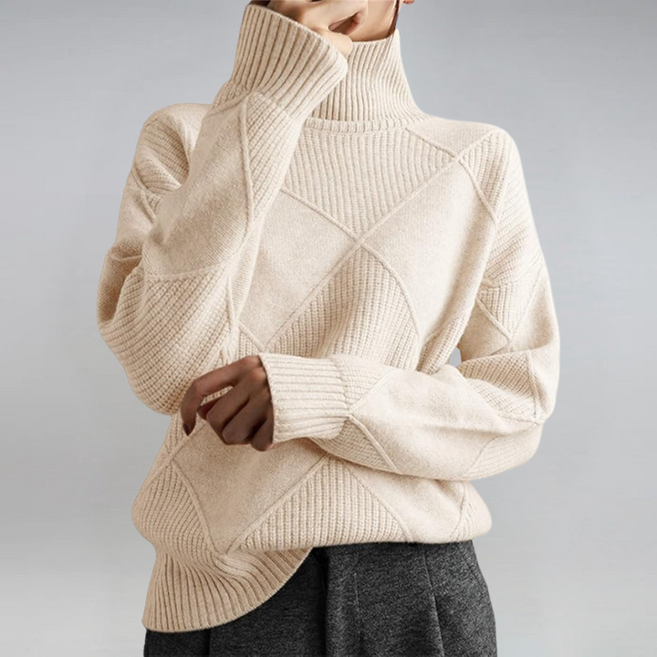 A woman in a stand-collar jumper with an elegant drape, styled with tailored trousers.