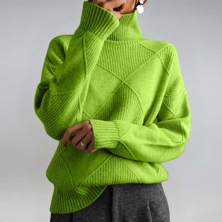 A woman in a stand-collar jumper with an elegant drape, styled with tailored trousers.